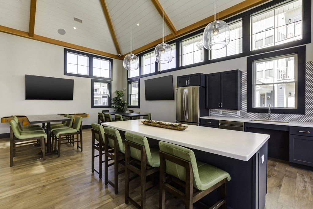 A kitchen with a long island and chairs.