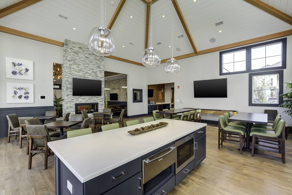 A modern kitchen with a stone fireplace and a large island.