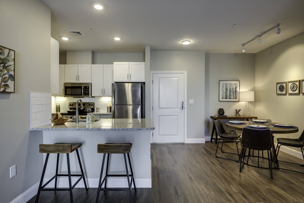 A kitchen with a bar area and a dining table.
