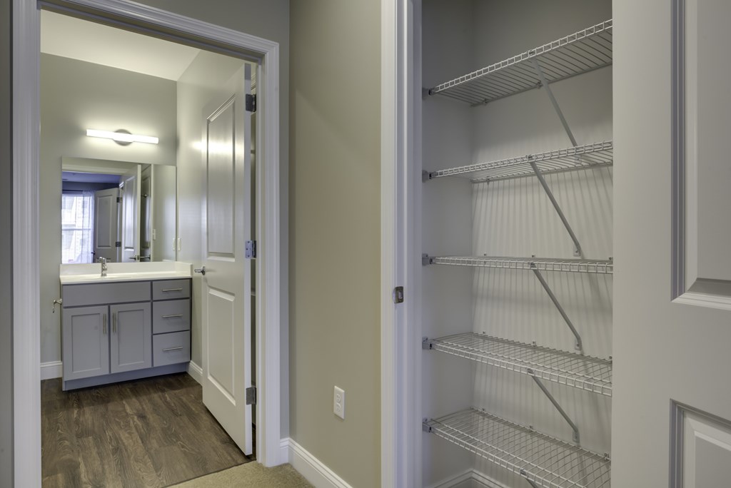 A white kitchen with a white fridge and a white pantry.