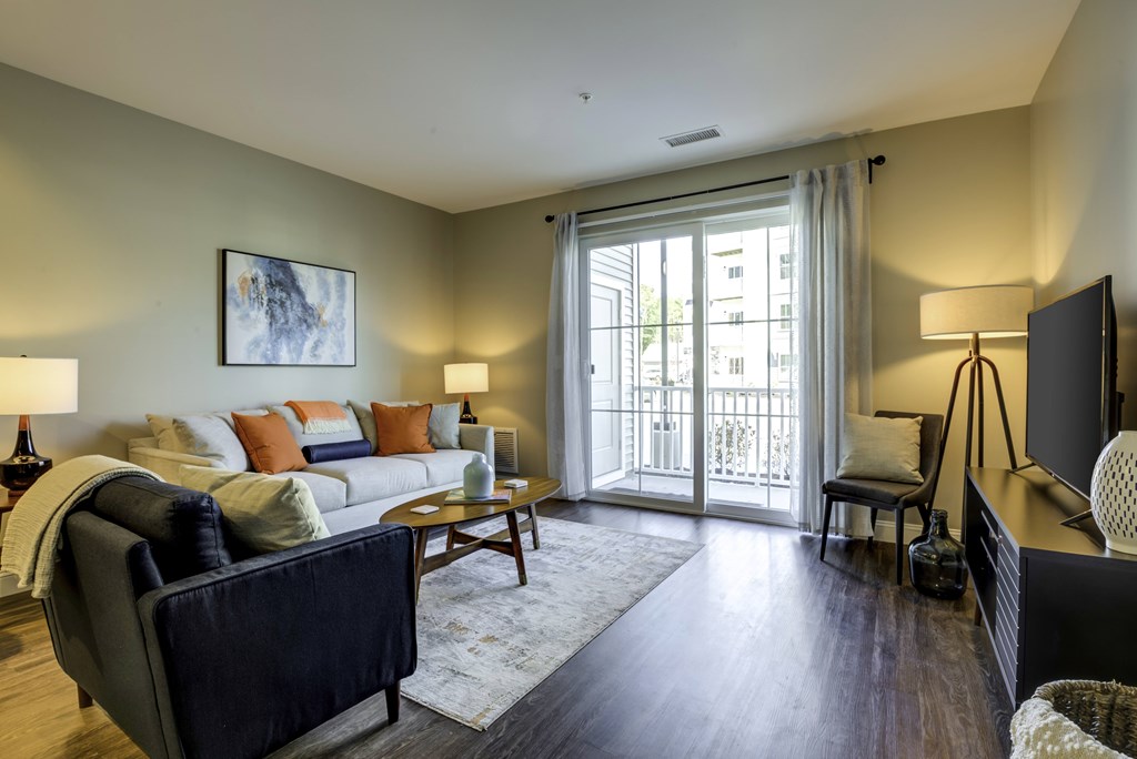 A living room with a couch, chair, and television.