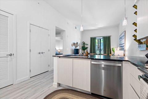 A kitchen with white cabinets and a stainless steel sink.
