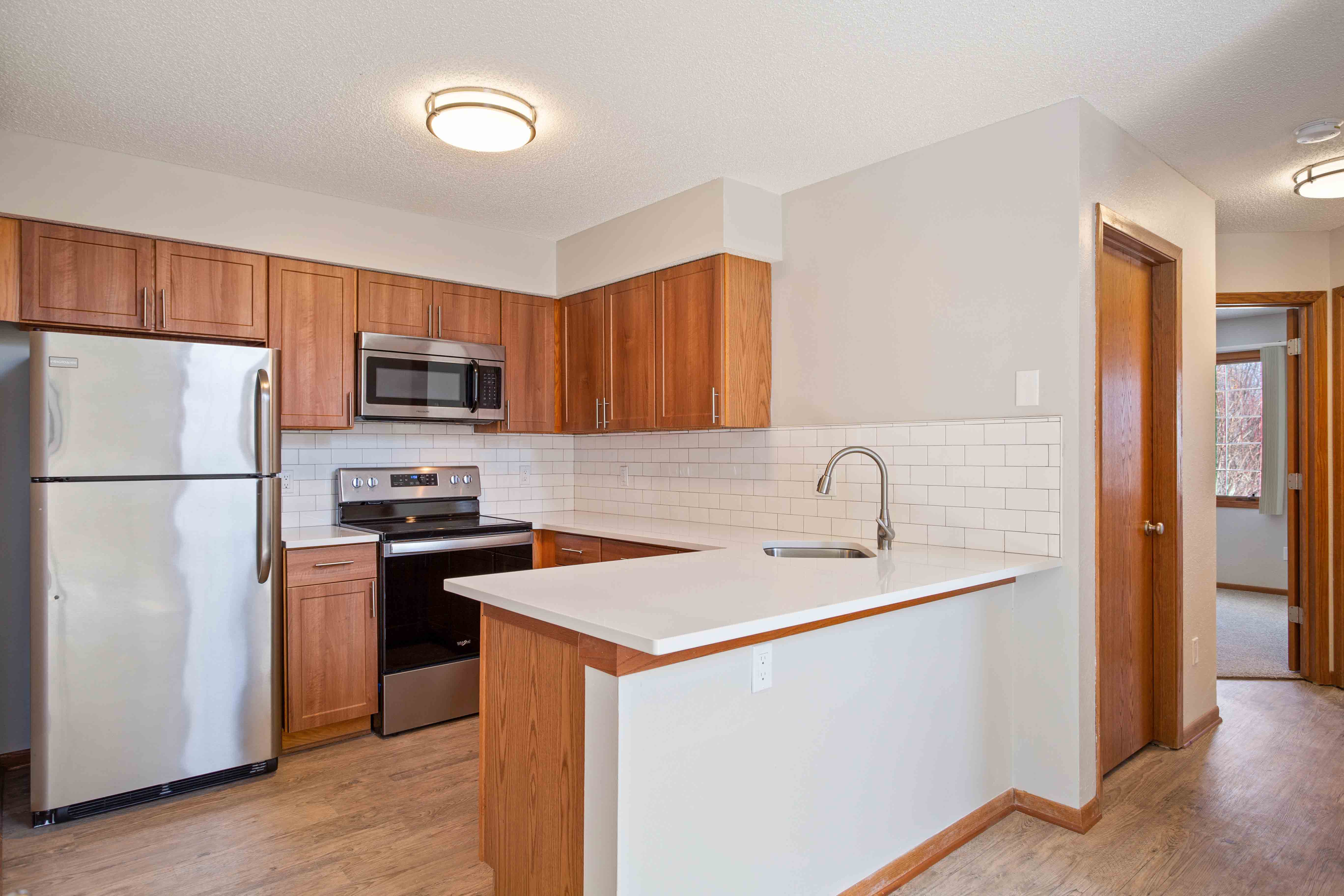 Full view of updated kitchen with stainless steel appliances & hardwood flooring