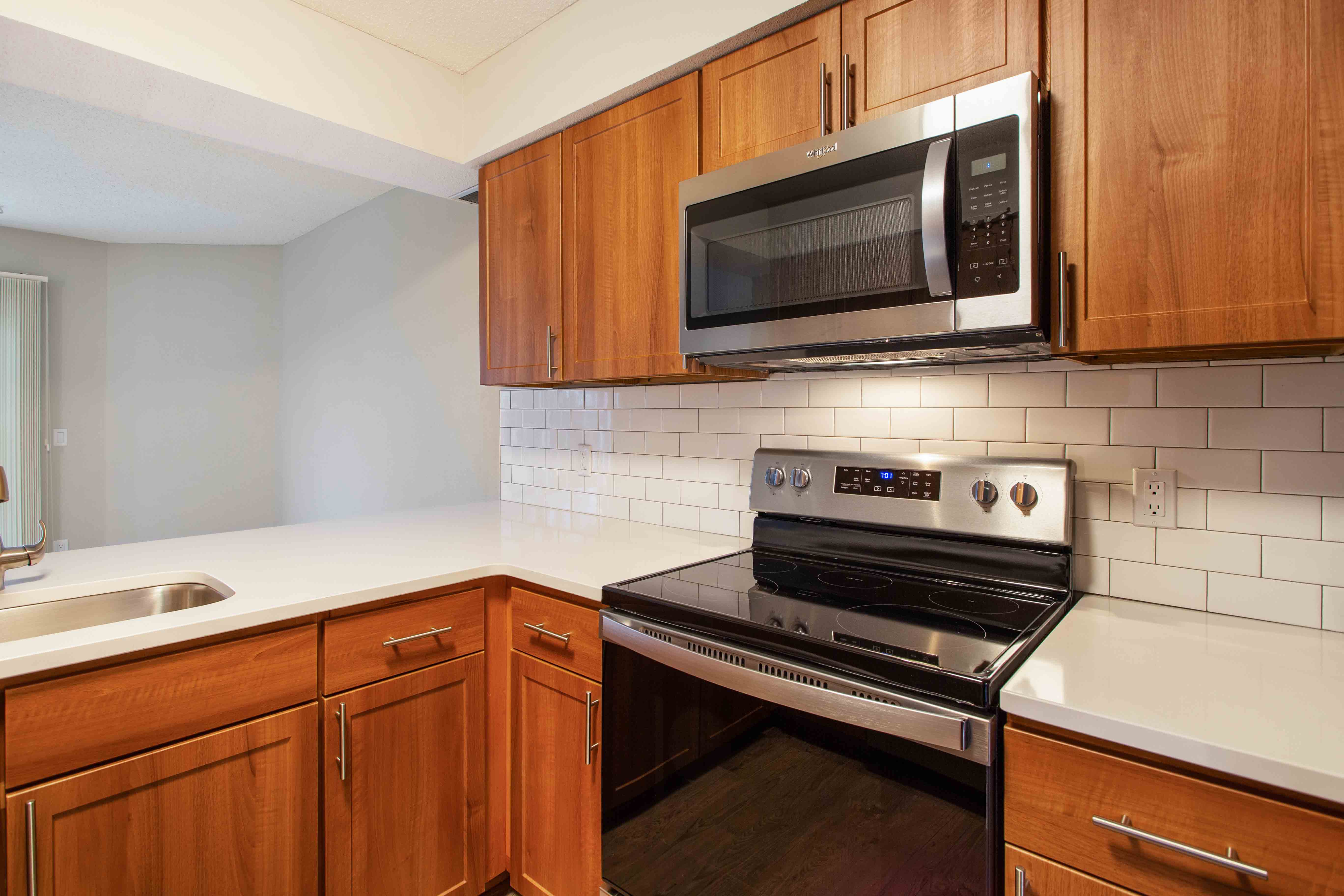 Updated kitchen with stainless steel appliances and tile backsplash