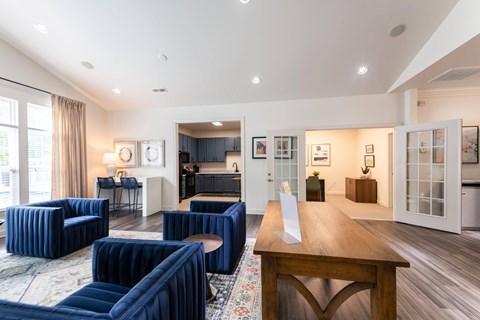A living room with blue chairs and a wooden table.