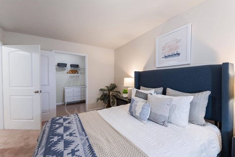 A bedroom with a large bed and a painting on the wall.