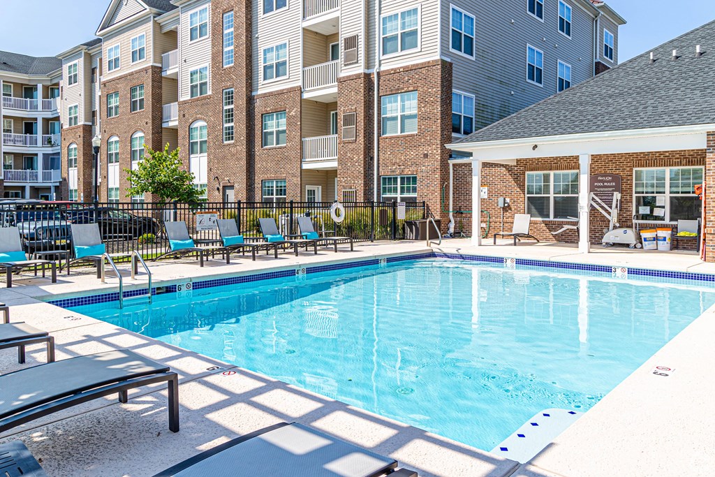 A large swimming pool in front of apartment buildings.