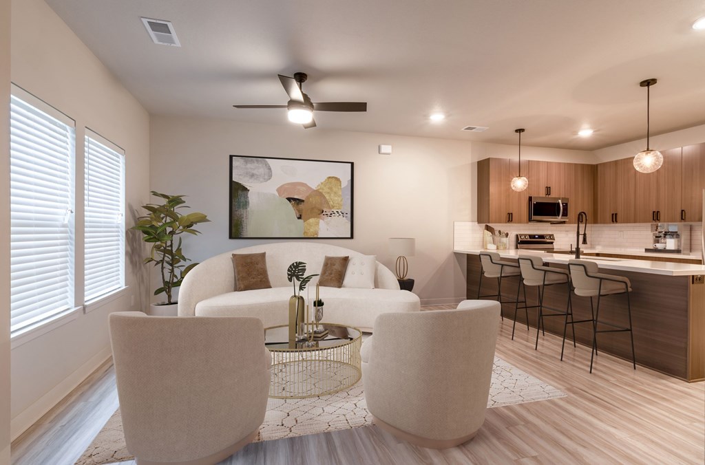 a living room and kitchen with white couches and chairs