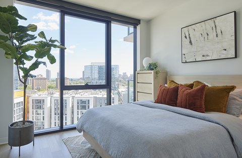 A bedroom with a large bed and a view of the city.