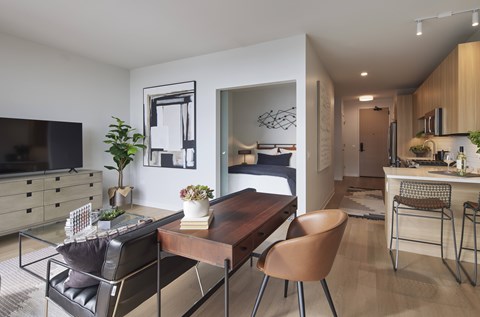 A modern living room with a wooden dining table and chairs.