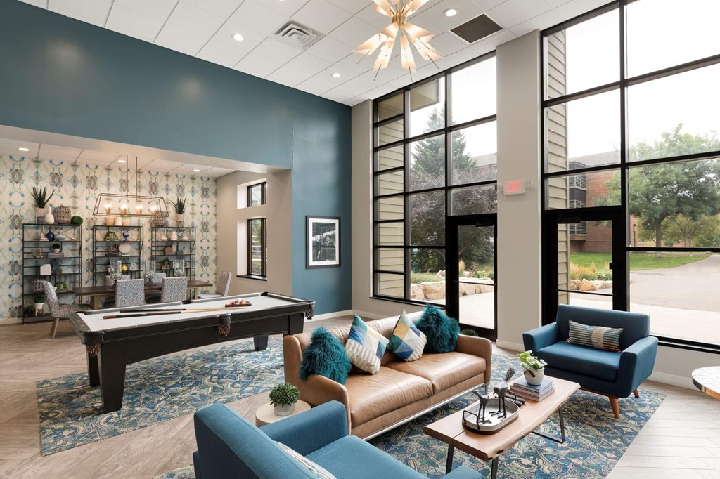 a clubhouse with a pool table and couches