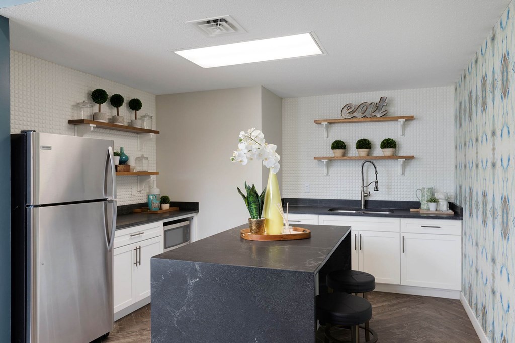 a kitchen with white cabinets and a stainless steel refrigerator