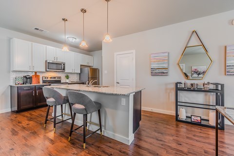 A kitchen with a bar and stools.