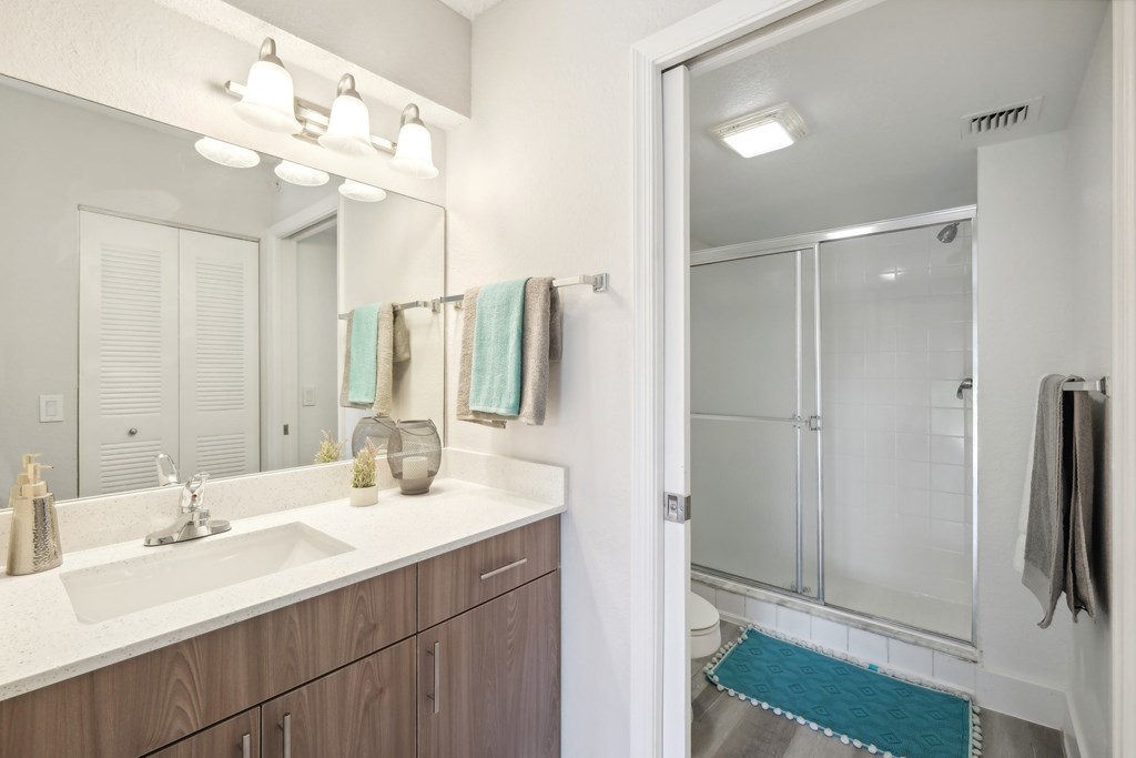 A bathroom with a white sink and a mirror above it.