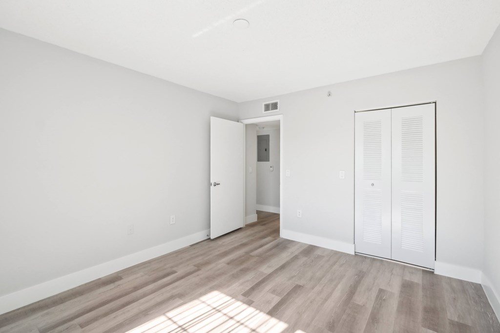 A room with a white door and a white cabinet with a glass door.
