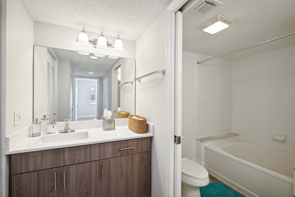 A white bathroom with a white tub and a white sink.