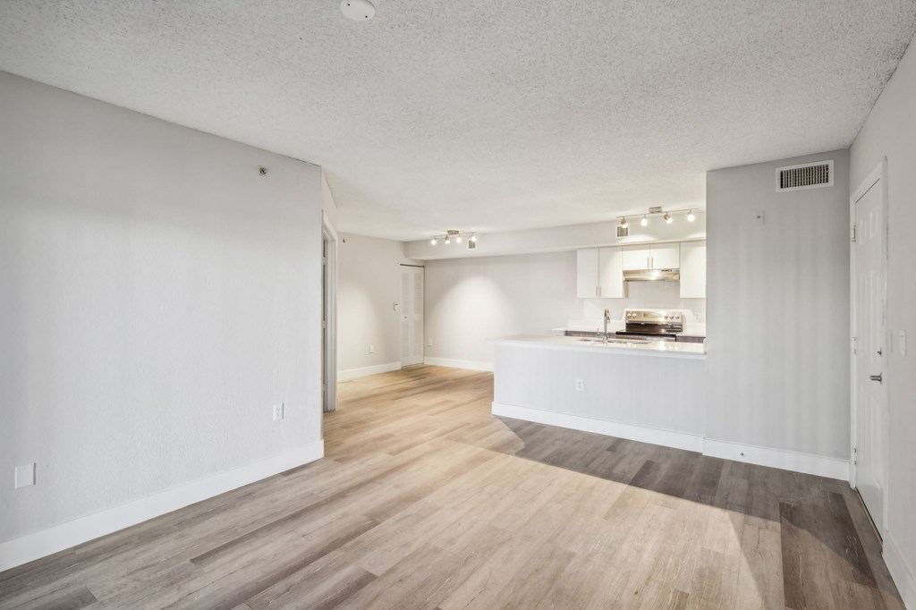 A room with a white wall and a wooden floor.