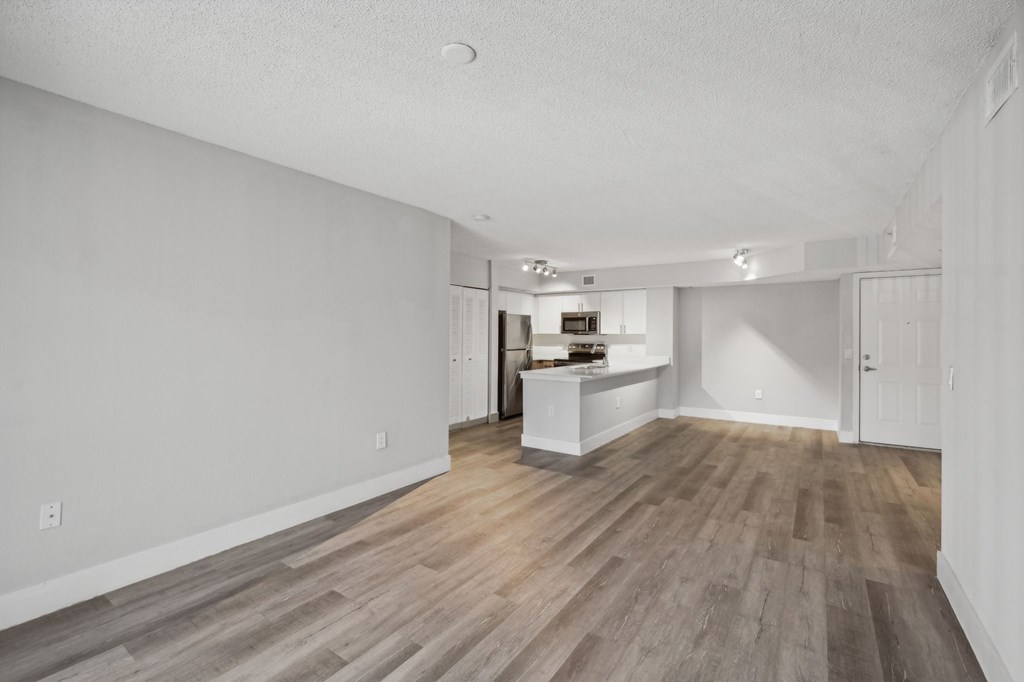 A room with wooden flooring and white walls.