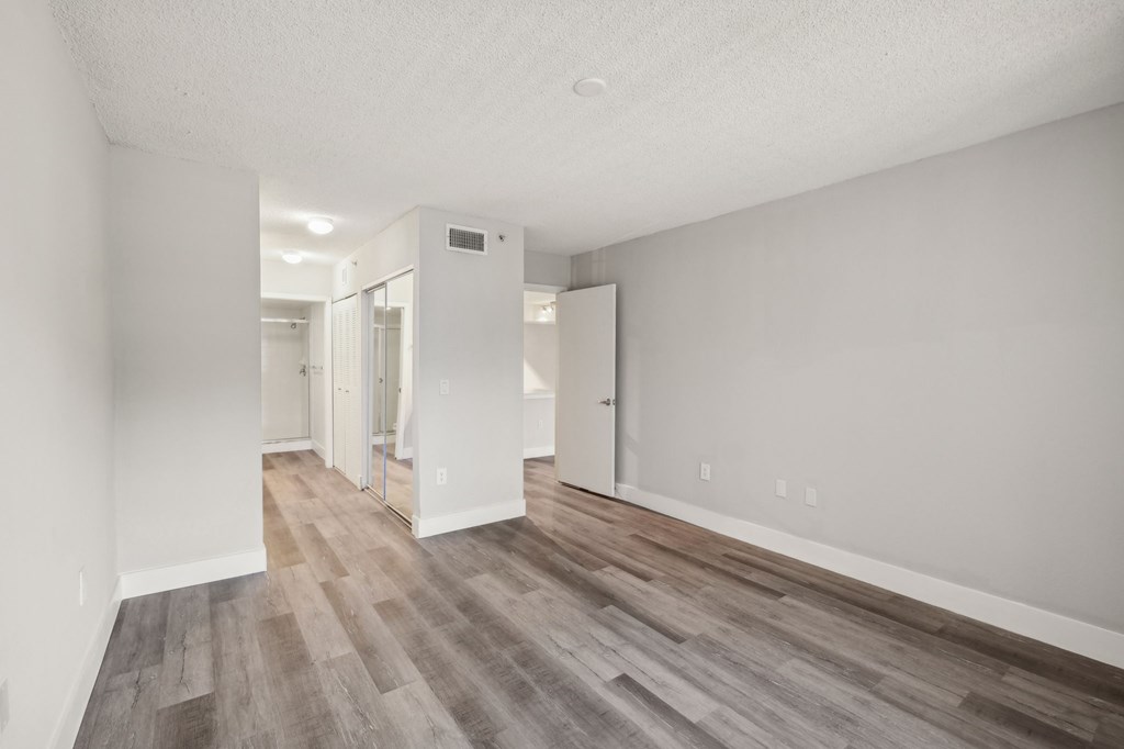 A room with a white wall and a wooden floor.