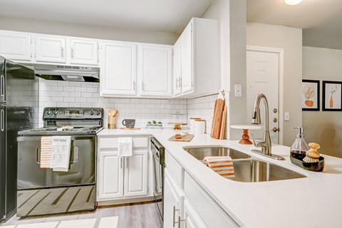 a large kitchen with white cabinets and stainless steel appliances