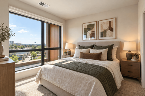 A bedroom with a large bed and a view of the city.