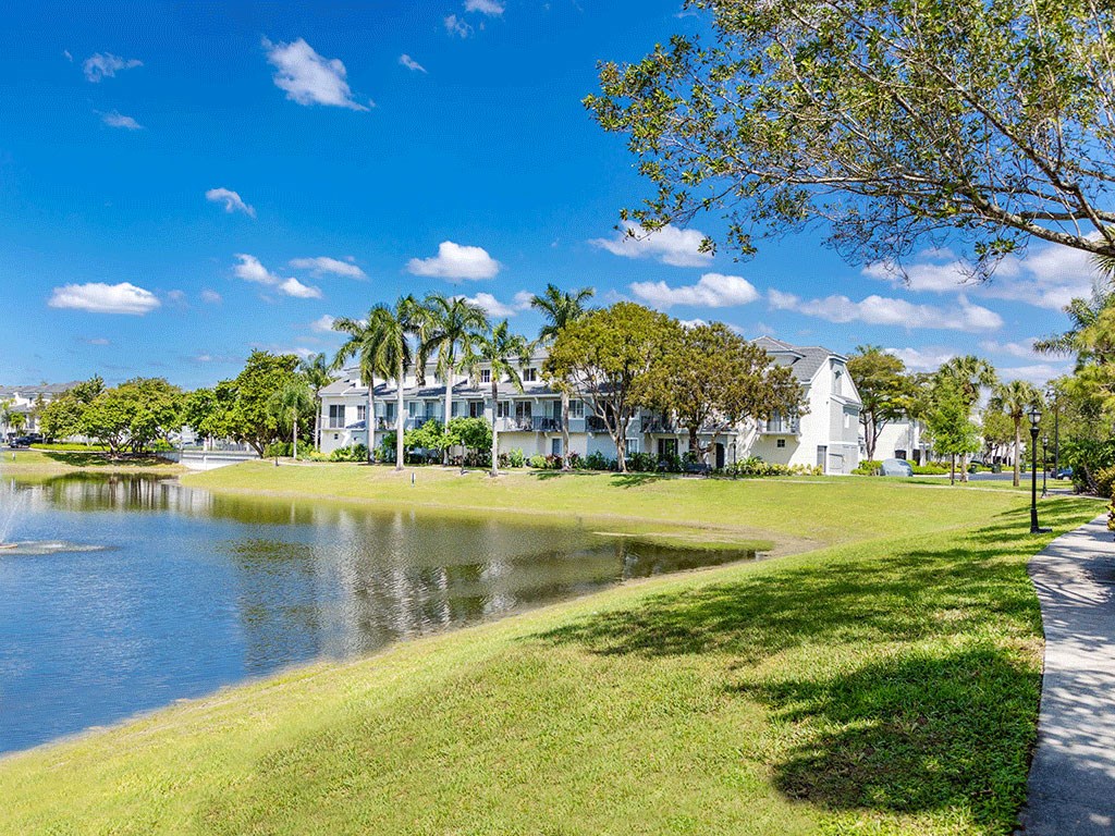 the house is across the water from a park with trees