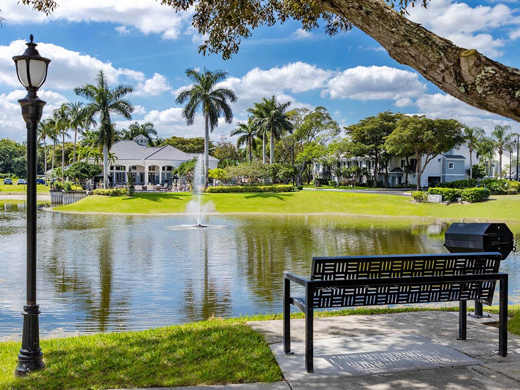 a park bench overlooking a pond with a fountain
