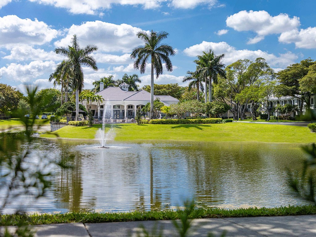 a large pond with a fountain in front of a house