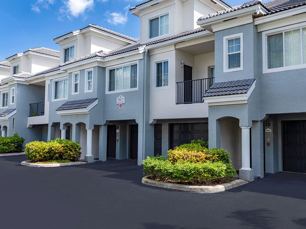 a row of townhomes with cars parked in front of them