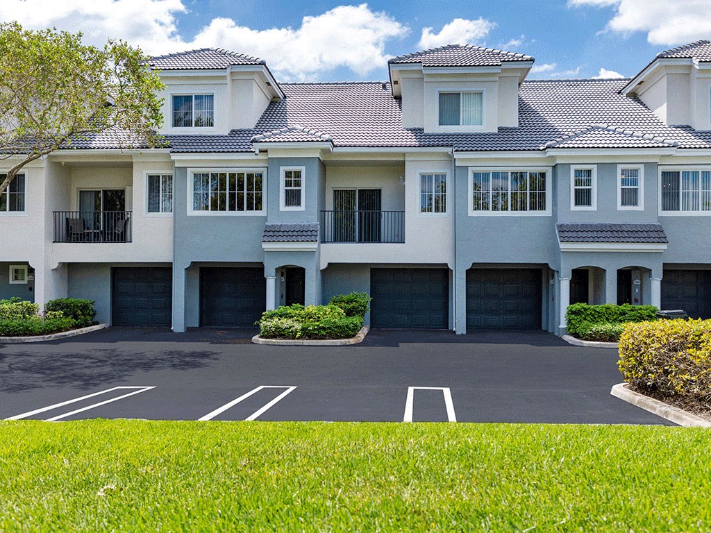 a large white house in front of a parking lot