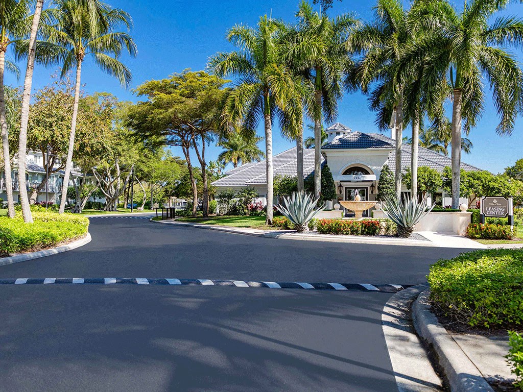 a street in front of a house with palm trees