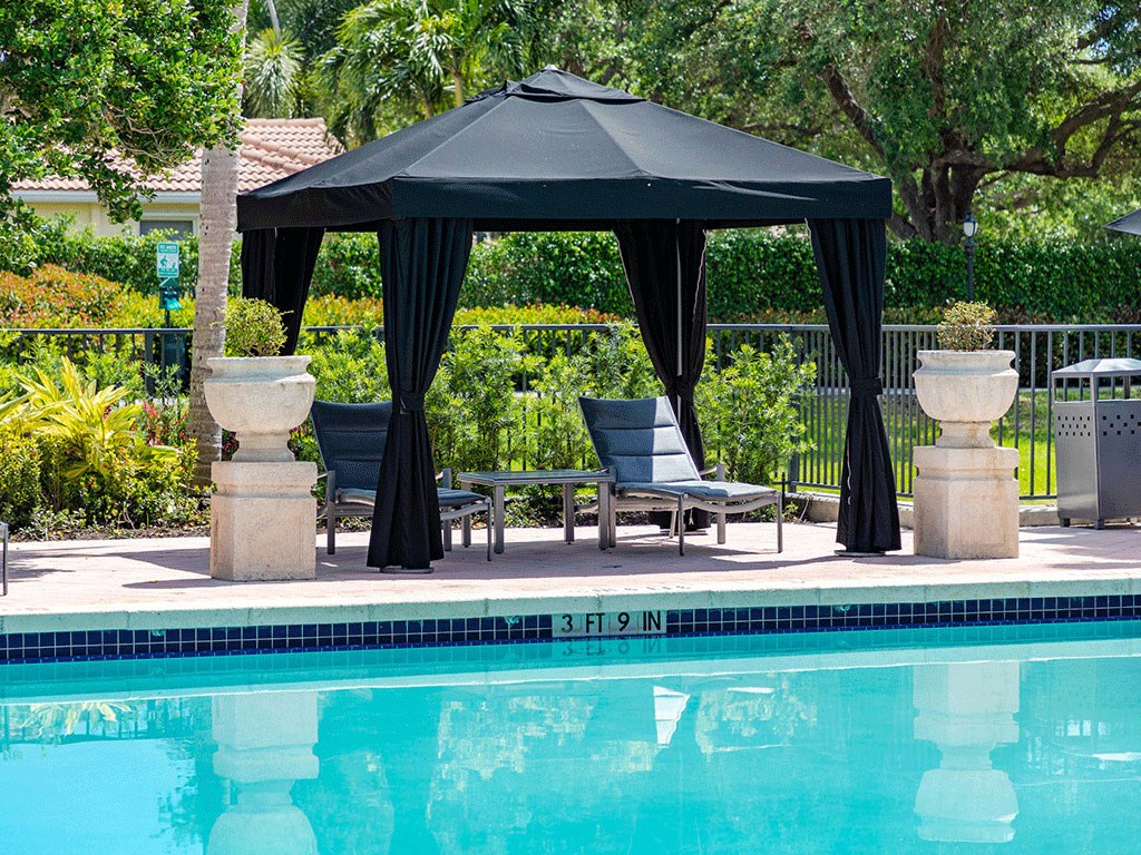 a gazebo with a canopy next to a swimming pool