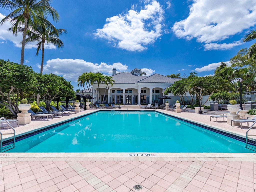a large swimming pool in front of a mansion
