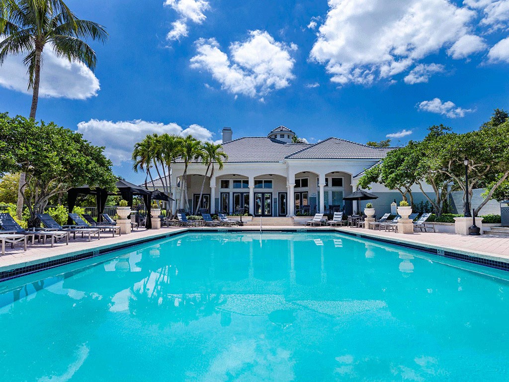 a large swimming pool in front of a mansion