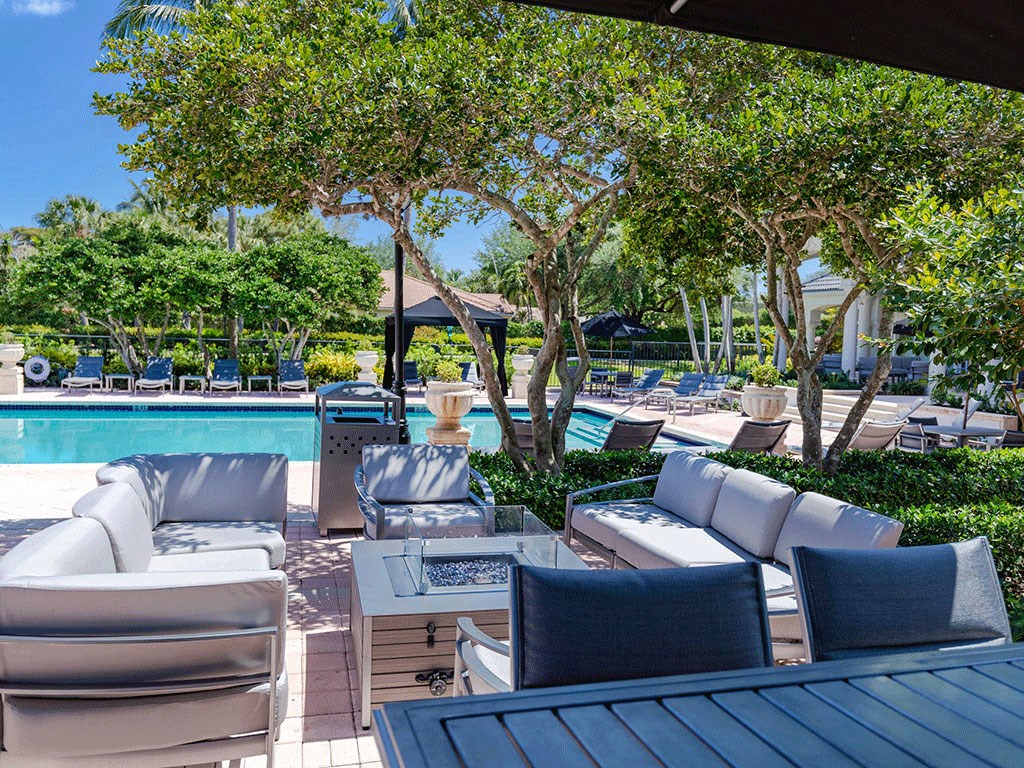 a swimming pool with lounge chairs and tables at a resort