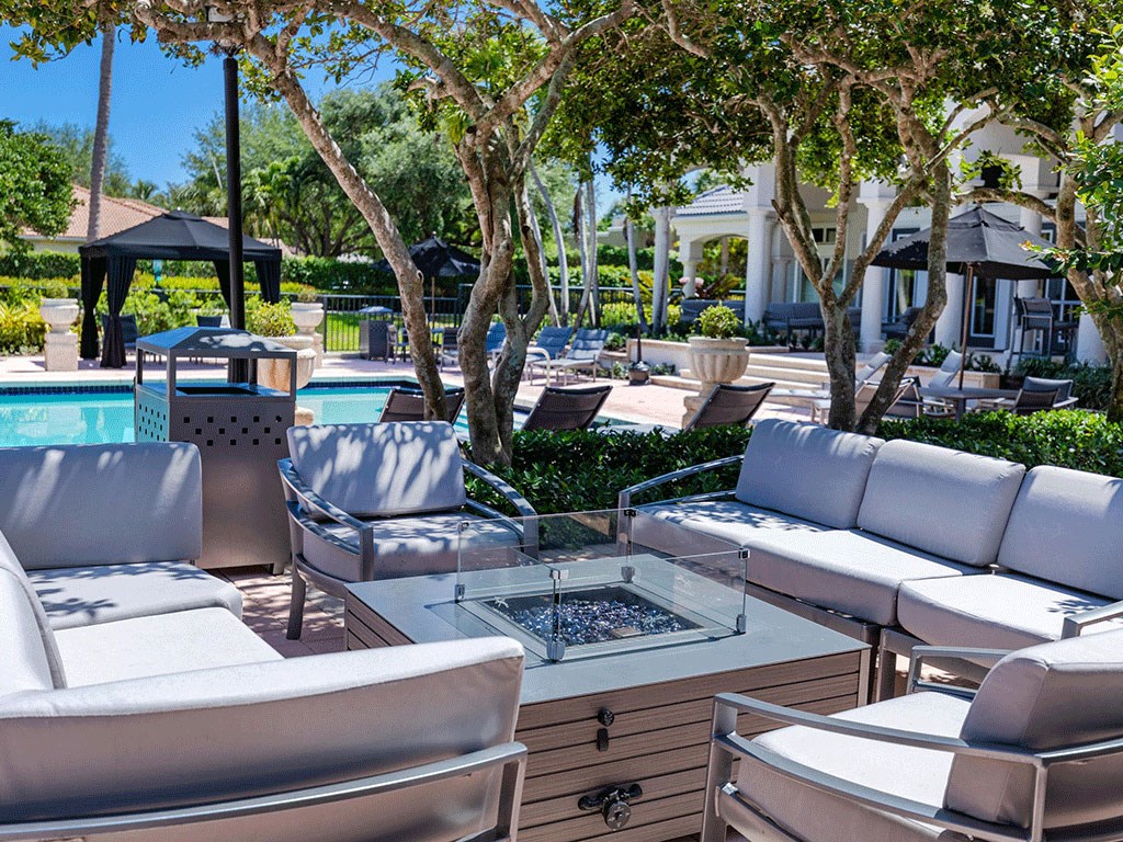 a lounge area with chairs and tables and a pool