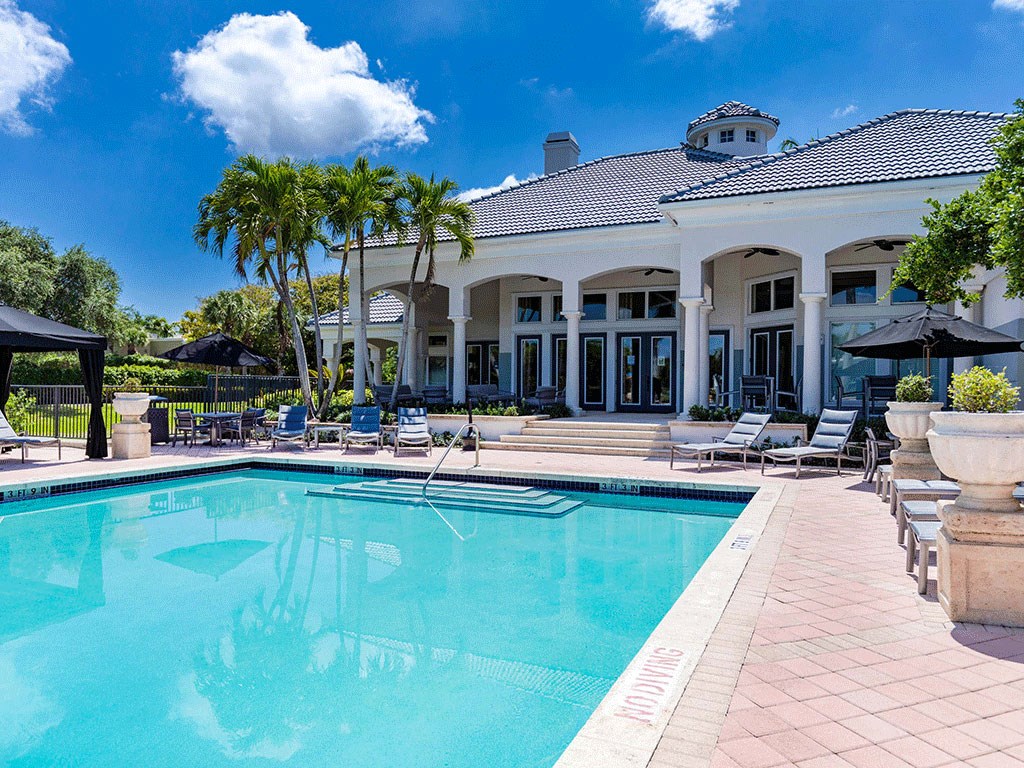 a large swimming pool in front of a white house