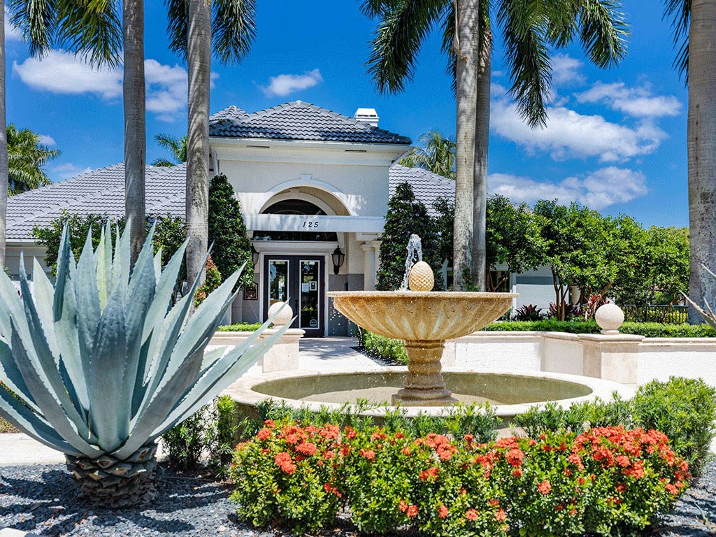 a fountain in a garden in front of a building