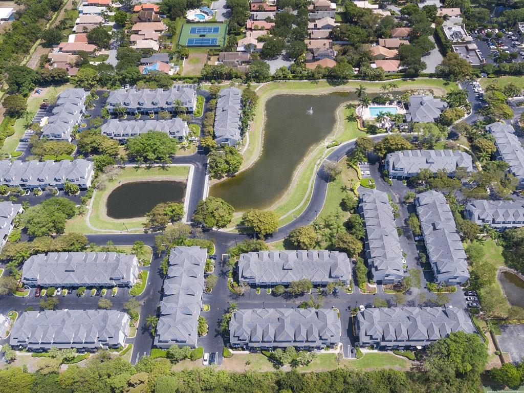 an aerial view of a neighborhood of houses and a pond