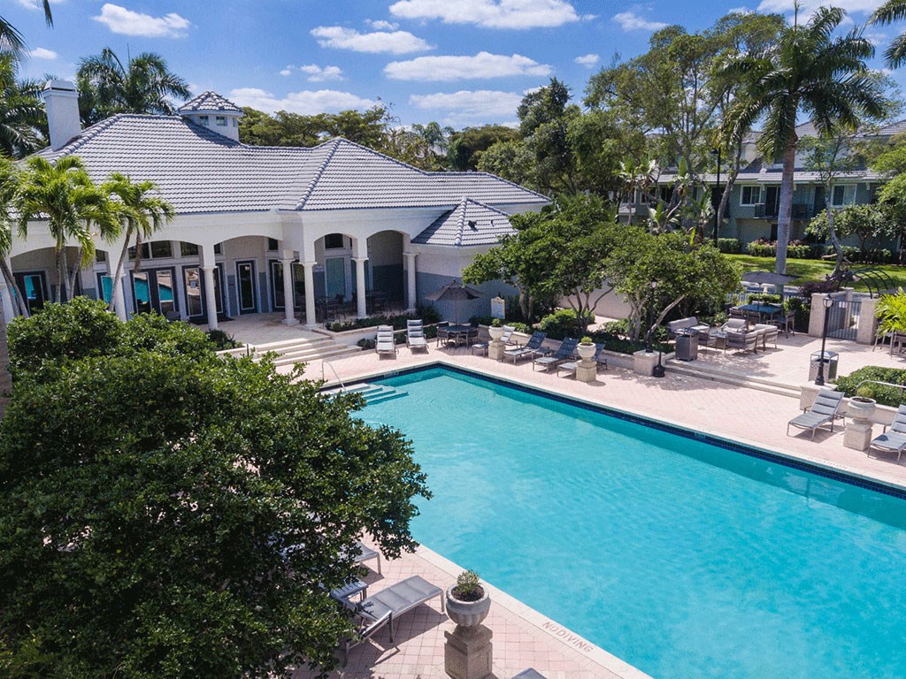a large swimming pool in front of a mansion