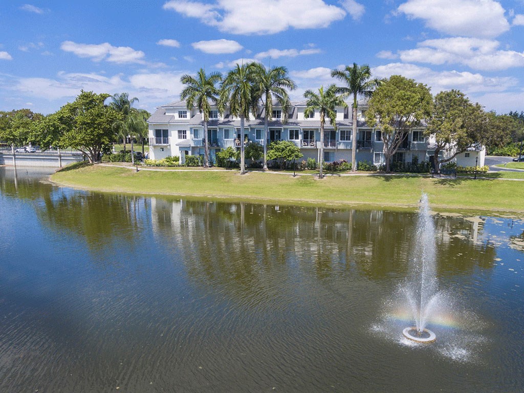 a fountain in the water in front of a house