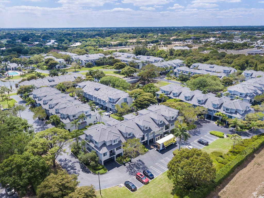 an aerial view of a neighborhood of houses with cars parked in a parking lot