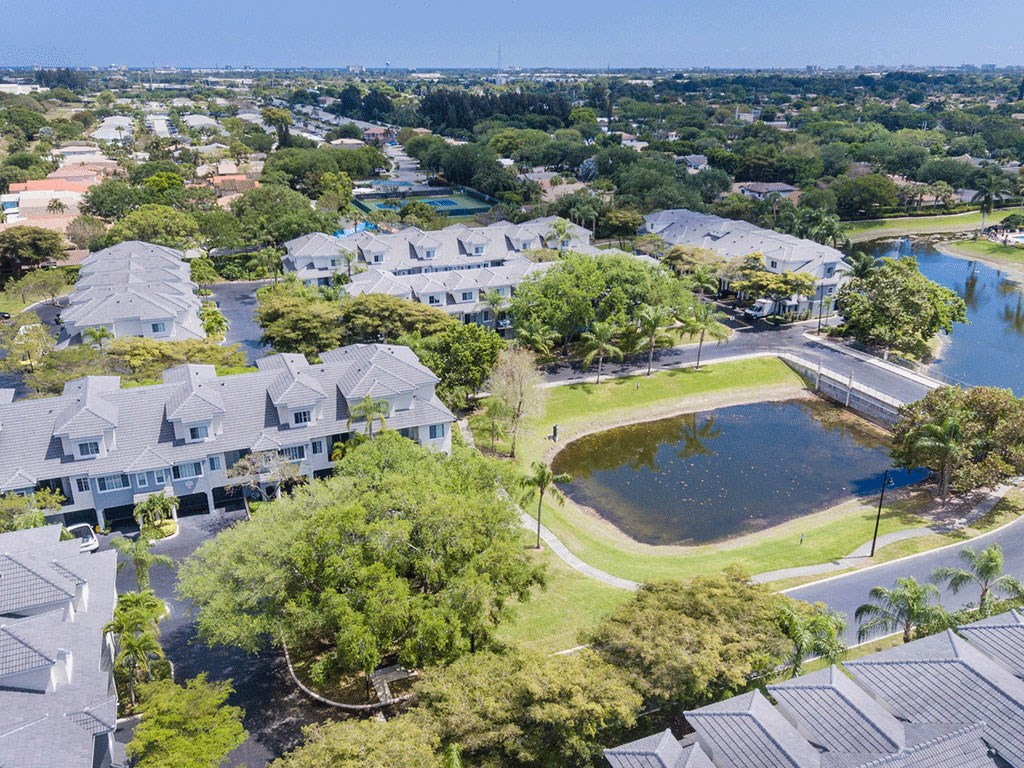 an aerial view of a neighborhood with a pond and houses