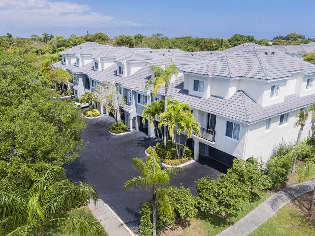 a large white house with palm trees in front of it