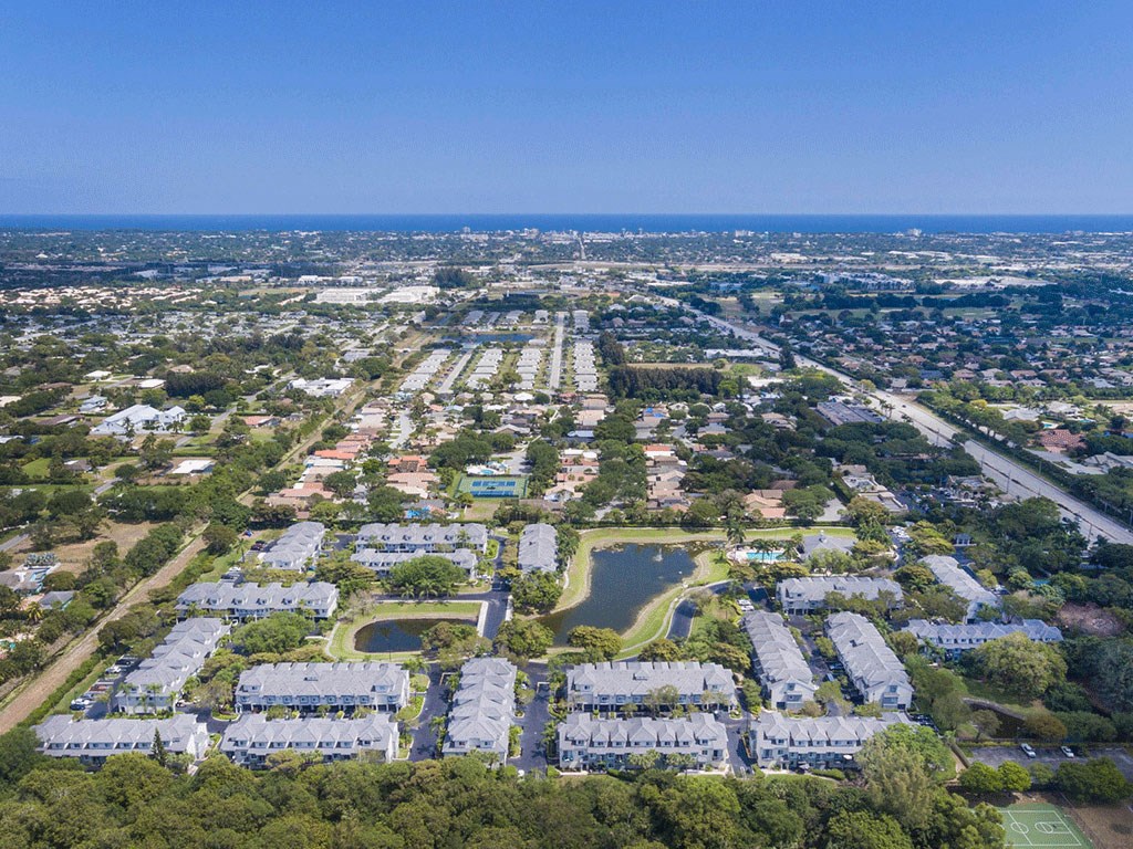 an aerial view of a city with houses and a pond