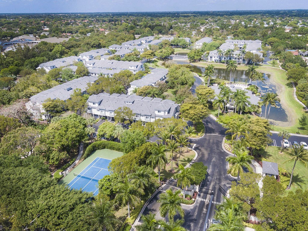 an aerial view of the property with houses and a tennis court