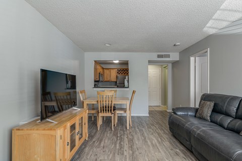 A living room with a black leather couch and a wooden entertainment center.