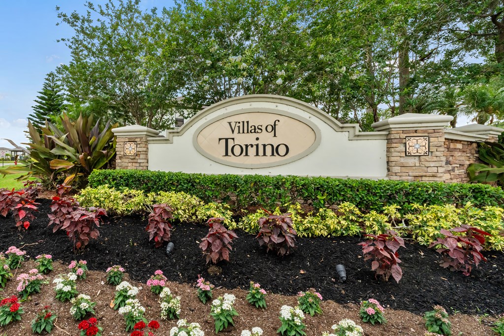the sign for villas of torino at the entrance to the subdivision with plants