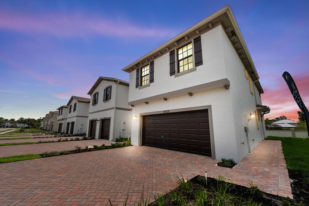 a group of houses with a driveway and a garage door