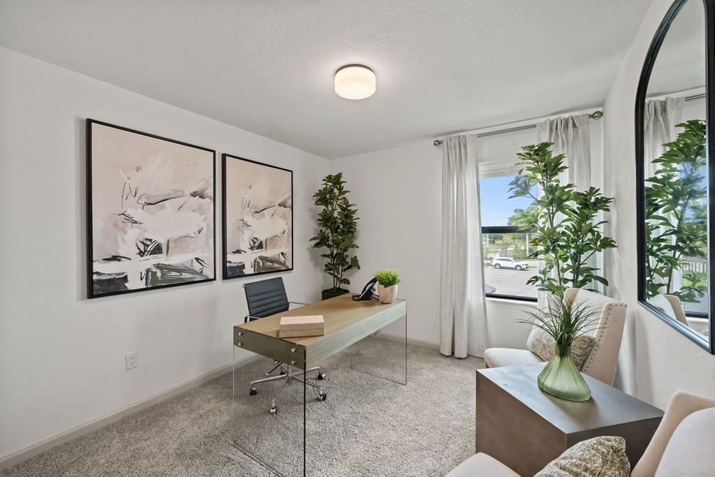 the living room of a home with a desk and a window